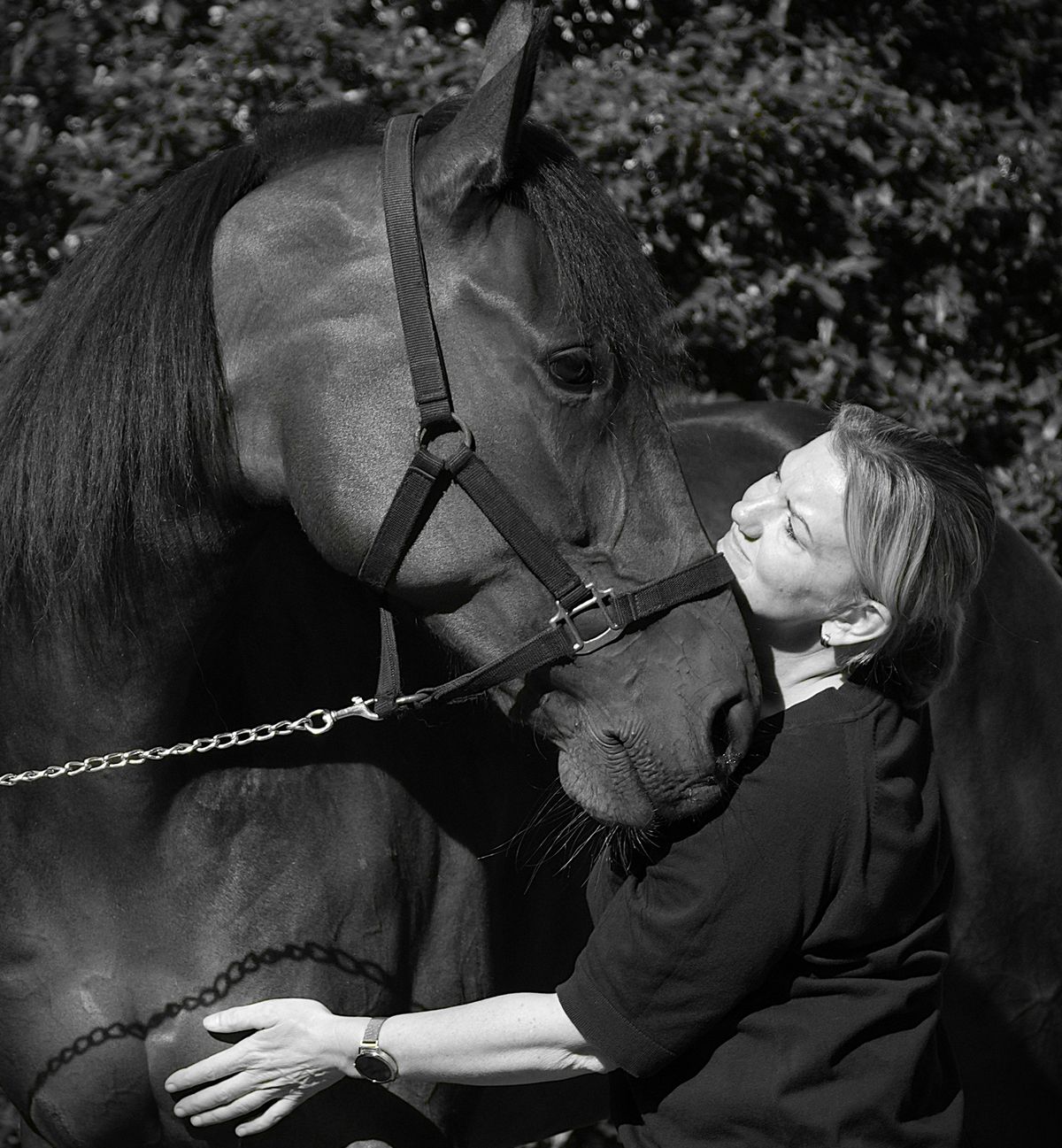 Zwart-witfoto: Marlous staat met haar hoofd tegen het hoofd van een paard